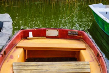 Göl kıyısında kürek çeken eski ahşap bir balıkçı teknesi. Yaz etkinliği.