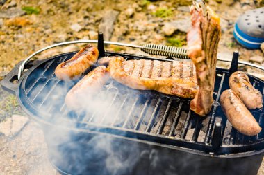 Et ve sosis ızgarada. Barbekü yemeği, yaz yemeği..