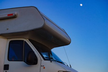 Rv caravan against evening sky with moon. Holidays and traveling in motor home.