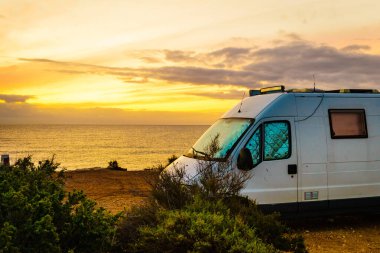 Kamp minibüsü, İspanya 'nın Murcia bölgesindeki Akdeniz kıyısında Costa Calida' da gün doğumunda. Doğa plajında kamp yapmak. Tatil ve karavanda yolculuk.