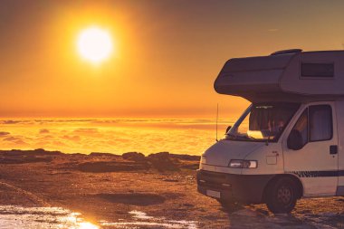 Karavan bulutların üstünde gün doğumunda. Portekiz 'in dağ doğasında bir karavan kamp arabası. Kamp aracıyla macera..