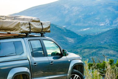 4x4 numaralı yol dışında kamp malzemeleri ve çatı çadırıyla donatılmış Fransa 'daki Verdon Vadisi' nde dağdan geçen bir araba..