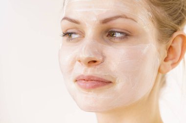 Yüzünde krem kozmetik, maske ve nem olan genç bir kadın. Güzellik tedavisi. Cilt bakımı.