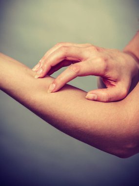 Dermatoloji, alerji ve sağlık sorunu. Genç erkek kaşıntılı kolunu Anti döküntü ile tırmalamak