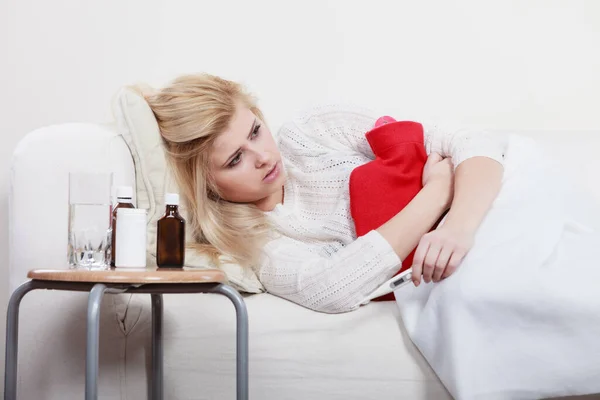 痛经和月经痉挛问题概念 女人有胃抽筋躺在 Cofa 感觉很不舒服 抱着热水袋感到一些欣慰 — 图库照片