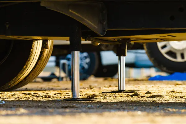 Kamp için otomatik seviye sistemi. Hidrolik sabit bacak kullanımda. Arkadaki karavan için mavi rampa tıkanıklığı.