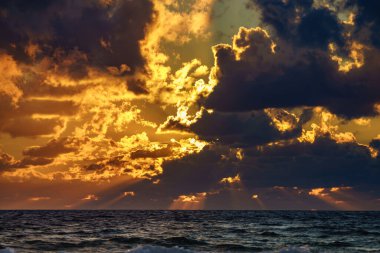 Gün batımı, deniz üzerindeki güneş ışığı, fırtınalı bulutlar. Akşamları deniz manzarası.