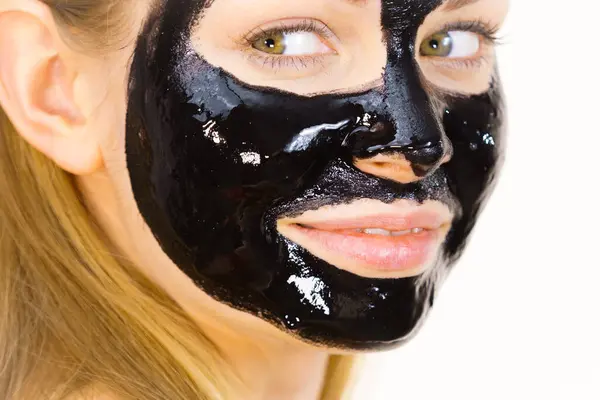 顔に化粧品を持つ若い女性は カルボデトックスマスクオフブラックピール スパトリートメント スキンケア ストック画像
