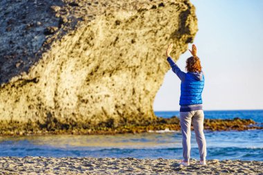 Cabo de Gata Nijar Doğal Parkı 'nda Monsul sahilinde yürüyen bir kadın. Almerya kıyıları. Turist çekmek için büyük lav oluşumu.