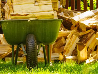 Dışarıda odun yığını ve el arabası var. Kış için hazırlık.