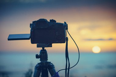 Tripodun üstündeki profesyonel kamera deniz üzerinde güneşin doğuşunu gösteren bir video çekiyor. Fotoğraf:.