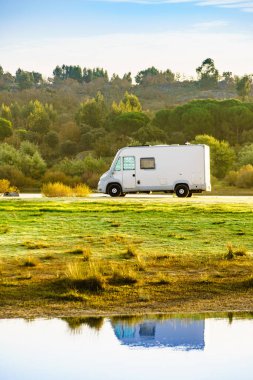 Doğada kamp yapmak. Göl kıyısındaki kamp aracı suya yansıyor. Povoa e Meadas Barajı, Castelo de Vide, Alentejo Portekiz. Karavanla git..
