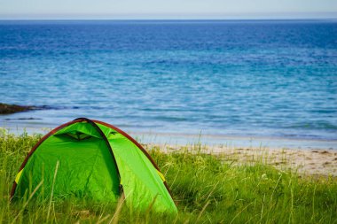 Yazın deniz kıyısında çadır. Okyanus kıyısında kamp yapmak. Lofoten takımadaları Norveç. Tatil ve seyahat.