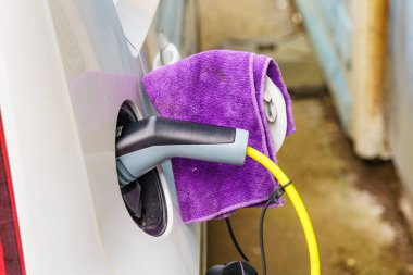 Şarj istasyonunda elektrik prizi olan elektrikli bir araba. Ekolojik ulaşım. Otomotiv teknolojisi kavramı.