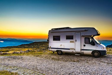 Gün batımında bulutların üstünde bir karavan. Portekiz 'in dağ doğasında bir karavan kamp arabası. Kamp aracıyla macera..