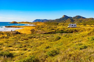 Sahilde kamp yapan karavanlı deniz manzaralı bir karavan. İspanya Murcia bölgesi, Calblanque Bölgesel Parkı.