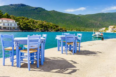 Deniz kenarındaki mavi masa ve sandalyeler deniz kıyısında Yunanistan 'da açık bir kafe restoranı açıyor. Yaz tatili.