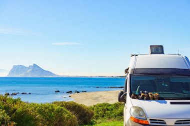 İspanya 'nın Akdeniz kıyısındaki karavan kamp aracı. Cebelitarık kayası ufukta. Tatil ve seyahet.