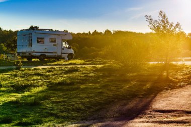 Camper vehicle camping on nature. Povoa e Meadas Dam in Castelo de Vide, Alentejo Portugal. Travel in motor home. clipart