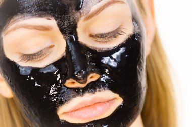 Yüzünde kozmetik olan genç bir kadın, karbonhidrat temizleme maskesi. Spa tedavisi. Cilt bakımı.