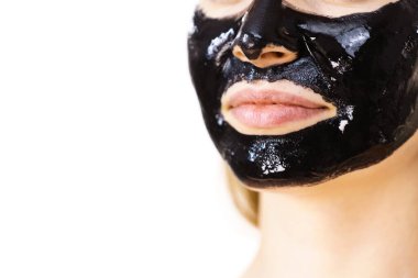 Yüzünde kozmetik olan genç bir kadın, karbonhidrat temizleme maskesi. Spa tedavisi. Cilt bakımı. Dudaklar ayrıntı.