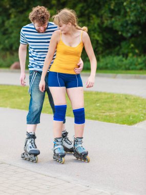 Bayram, aktif insanlar ve dostluk kavramı. Açık havada, kadın ve erkek paten birlikte şehir sokak üzerinde sürme paten üzerinde çift genç yerleştirmek