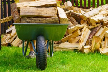 Dışarıda odun yığını ve el arabası var. Kış için hazırlık.