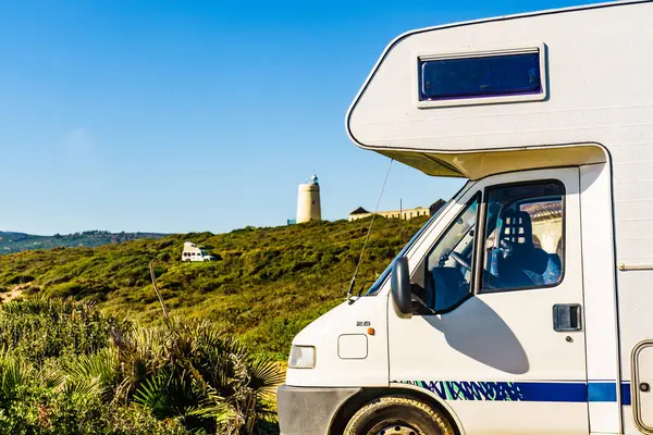 İspanya sahilinde bir karavan. Uzakta deniz feneri Carbonera.. Tatil ve seyyar evlerde seyahat.