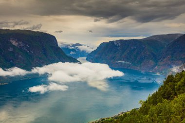 Aurlandsfjord deniz yüzeyinde bulutlar olan fiyort manzarası. Norveç İskandinavya 'sı. Ulusal turizm rotası Aurlandsfellet.