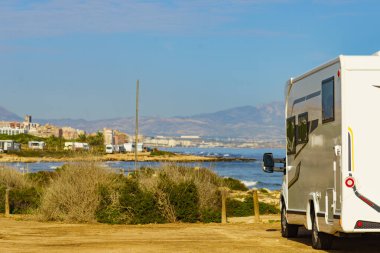 Akdeniz kıyısındaki karavan, uzakta Alicante şehri, Costa Blanca İspanya. Kumsalda vahşi bir kamp. Karavanla tatil gezisi..