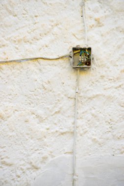 Beyaz bina duvarında elektrik kutusu var..