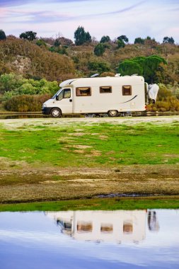 Doğada kamp yapmak. Göl kıyısındaki kamp aracı suya yansıyor. Povoa e Meadas Barajı, Castelo de Vide, Alentejo Portekiz. Karavanla git..