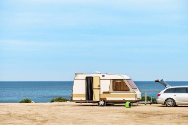 Karavan karavanı deniz kıyısında kamp yapıyor. Mobil evle tatil gezisi.