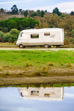 Doğada kamp yapmak. Göl kıyısındaki kamp aracı suya yansıyor. Povoa e Meadas Barajı, Castelo de Vide, Alentejo Portekiz. Karavanla git..