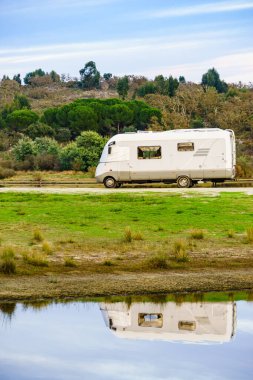 Doğada kamp yapmak. Göl kıyısındaki kamp aracı suya yansıyor. Povoa e Meadas Barajı, Castelo de Vide, Alentejo Portekiz. Karavanla git..
