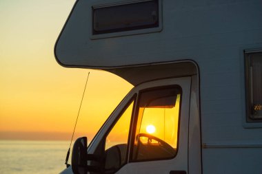 İspanya 'nın Akdeniz kıyısında gün batımında kamp aracı. Doğada kamp yapmak. Tatil ve karavanda seyahat.