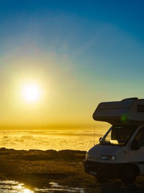 Karavan bulutların üstünde gün doğumunda. Portekiz 'in dağ doğasında bir karavan kamp arabası. Kamp aracıyla macera..