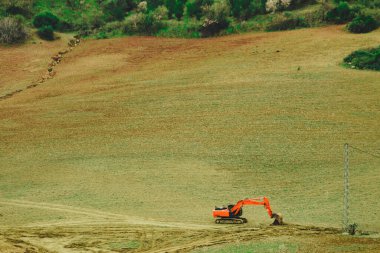 Kazıcı kazıcısı alan üzerinde çalışıyor.
