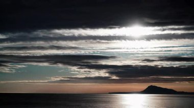 Sabah vakti denizin üzerinde hareket eden kara fırtınalı bulutlar. Gandia Sahili, Valencia İspanya manzarası. Montgo dağı kitlesi ufukta..