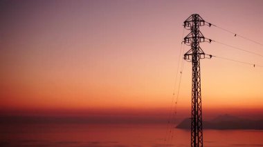 Gün batımında kıyı şeridi, elektrik iletim direkleriyle, elektrik hatları yüksek voltaj kuleleriyle. Ben roldan, Cabo de gata nijar, İspanya.