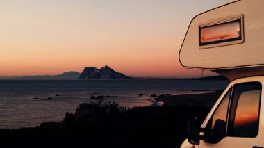 Sabah kumsalda karavan kampı, Punta Mala, Endülüs İspanya. Ufukta Cebelitarık kayası, İspanya kıyılarında İngiliz denizaşırı toprakları.