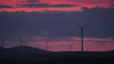 Gün batımında tepelerde rüzgar türbinleri. Ardales, Malaga ili, Endülüs İspanya yakınlarındaki yenilenebilir enerji üretimi için enerji jeneratörü çiftliği.
