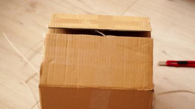 Boks yapıyorum. Elle açılan kahverengi karton kutu, kargo paketi. Teslimat konsepti.