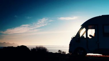 Kamp aracı sabah deniz kenarında kamp yapıyor. Karavanla seyahat ediyorum. Karavan tatili. Doğa ve faaliyetler.