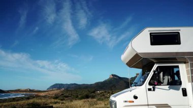 Bulutların deniz kıyısındaki karavanın üzerinden geçişi Calblanque doğal parkında, Murcia İspanya 'da. Karavan tatili.