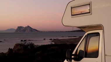 Sabah kumsalda karavan kampı, Punta Mala, Endülüs İspanya. Ufukta Cebelitarık kayası, İspanya kıyılarında İngiliz denizaşırı toprakları.