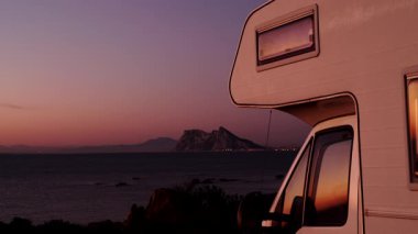 Sabah kumsalda karavan kampı, Punta Mala, Endülüs İspanya. Ufukta Cebelitarık kayası, İspanya kıyılarında İngiliz denizaşırı toprakları.