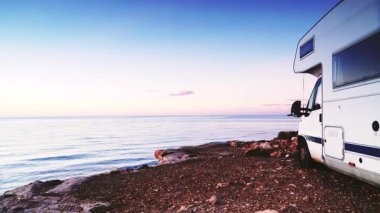 Kamp aracı deniz kenarında kamp yapıyor. Karavanla seyahat ediyorum. Karavan tatili. Doğa ve faaliyetler.