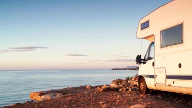 Kamp aracı deniz kenarında kamp yapıyor. Karavanla seyahat ediyorum. Karavan tatili. Doğa ve faaliyetler.