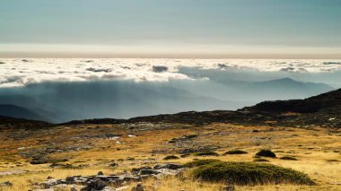 Yüksek dağların üzerinde kabarık bulutlar. Portekiz 'deki Torre Dağı tepesinden Serra da Estrela' nın görüntüsü.